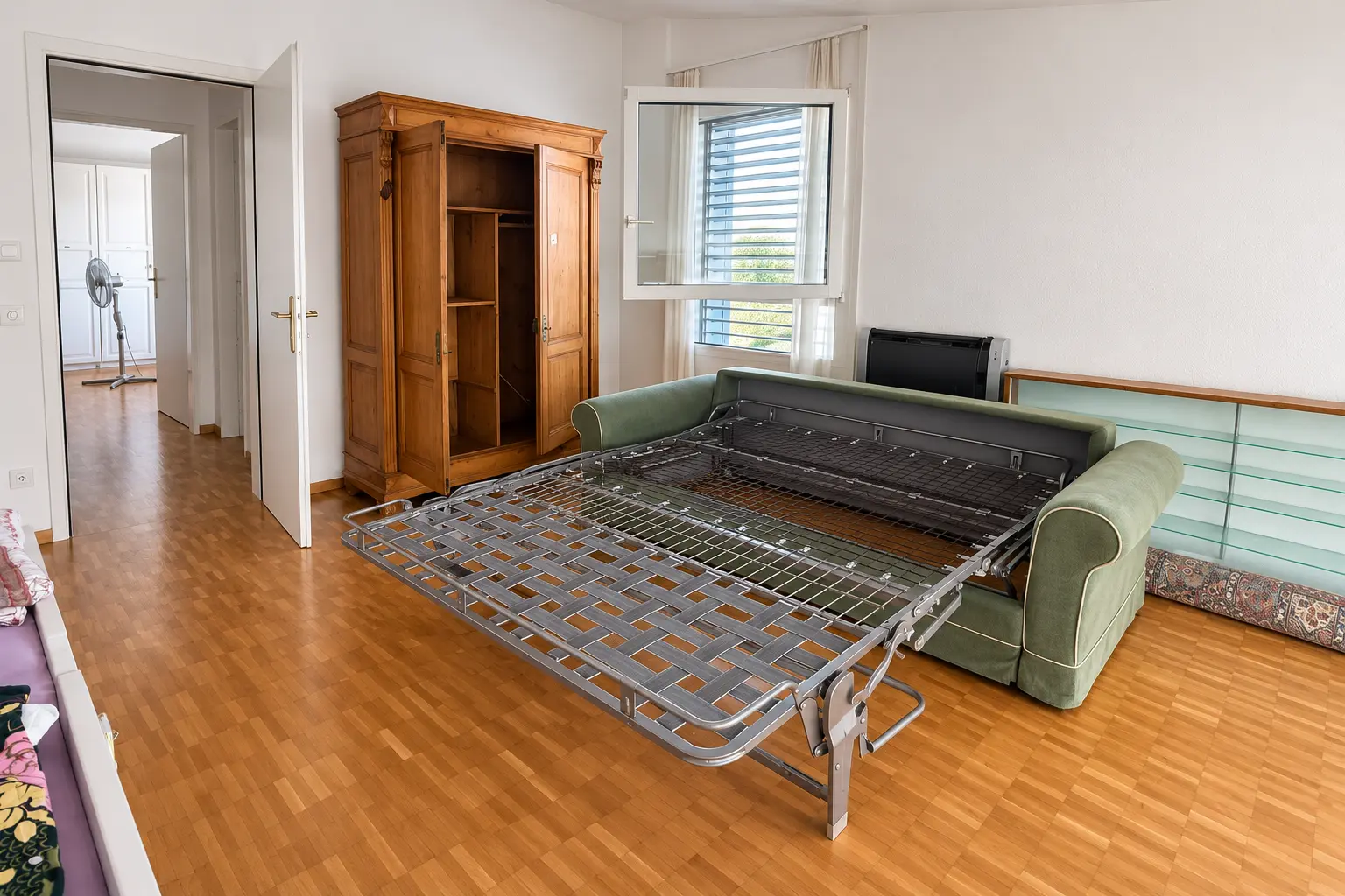 Wohnzimmer mit Sofa und Schrank während einer Wohnungsräumung im Tessin